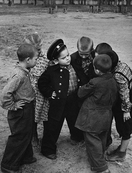 Первоклассник хвастается новой формой перед дворовыми друзьями. СССР. 1955
